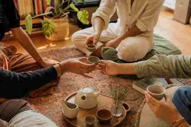 Friends sharing a gongfu tea session outdoors.